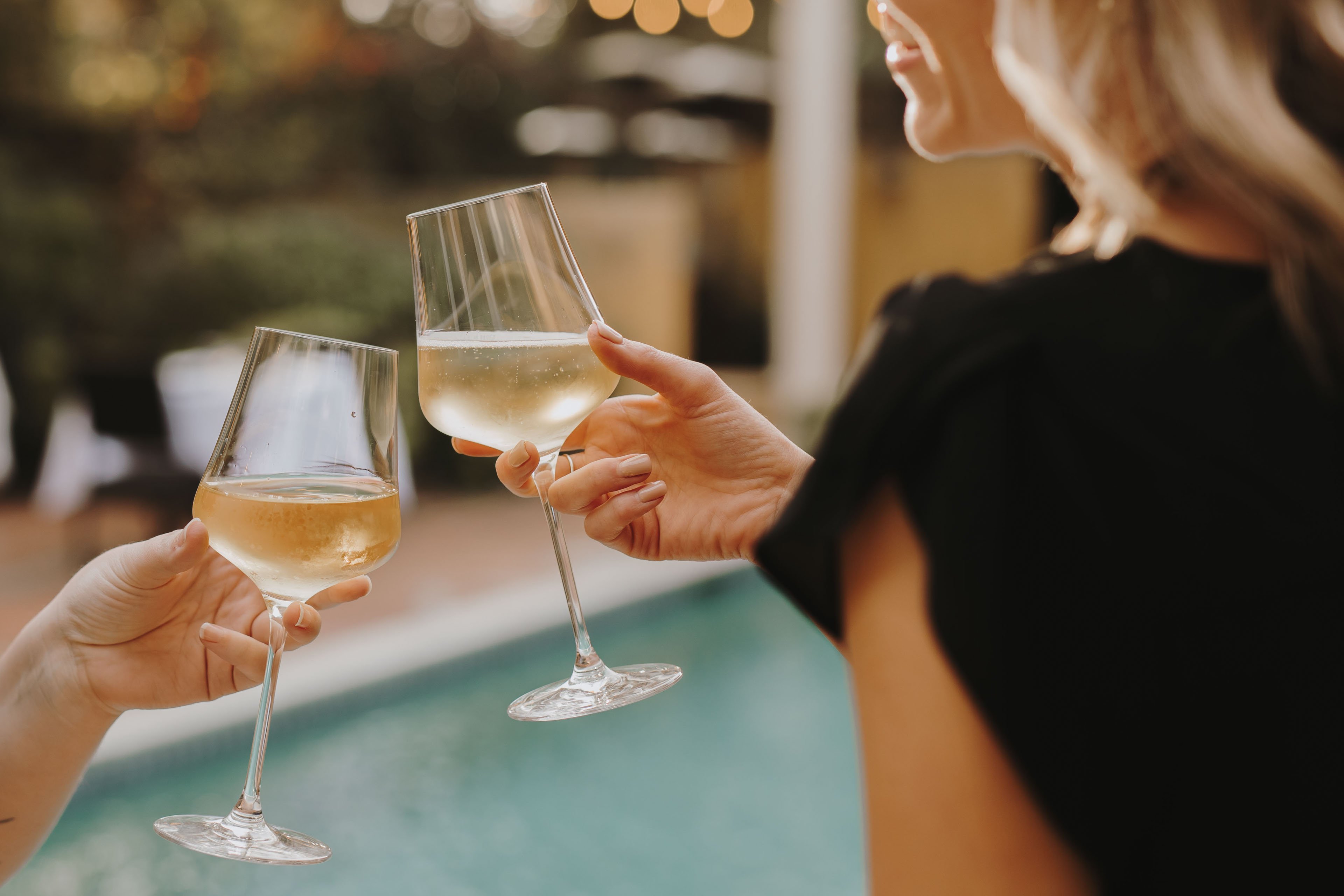 Two people cheersing their glasses outdoors copy