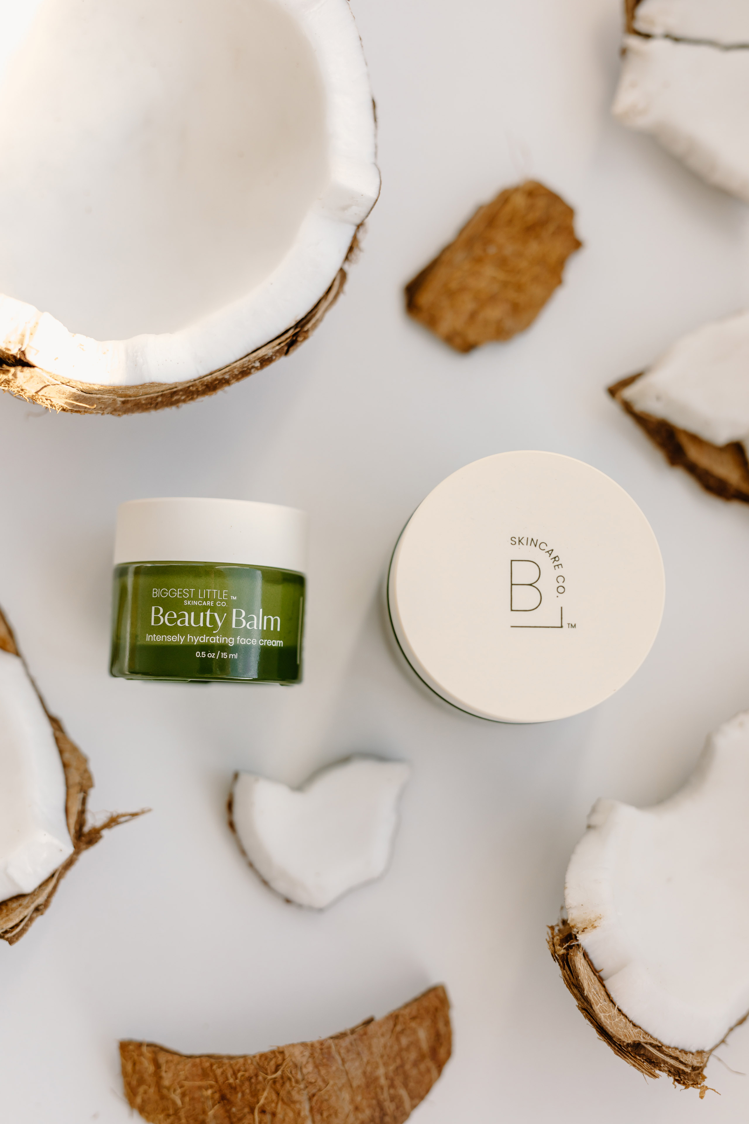 a green jar surrounded by broken coconut bits