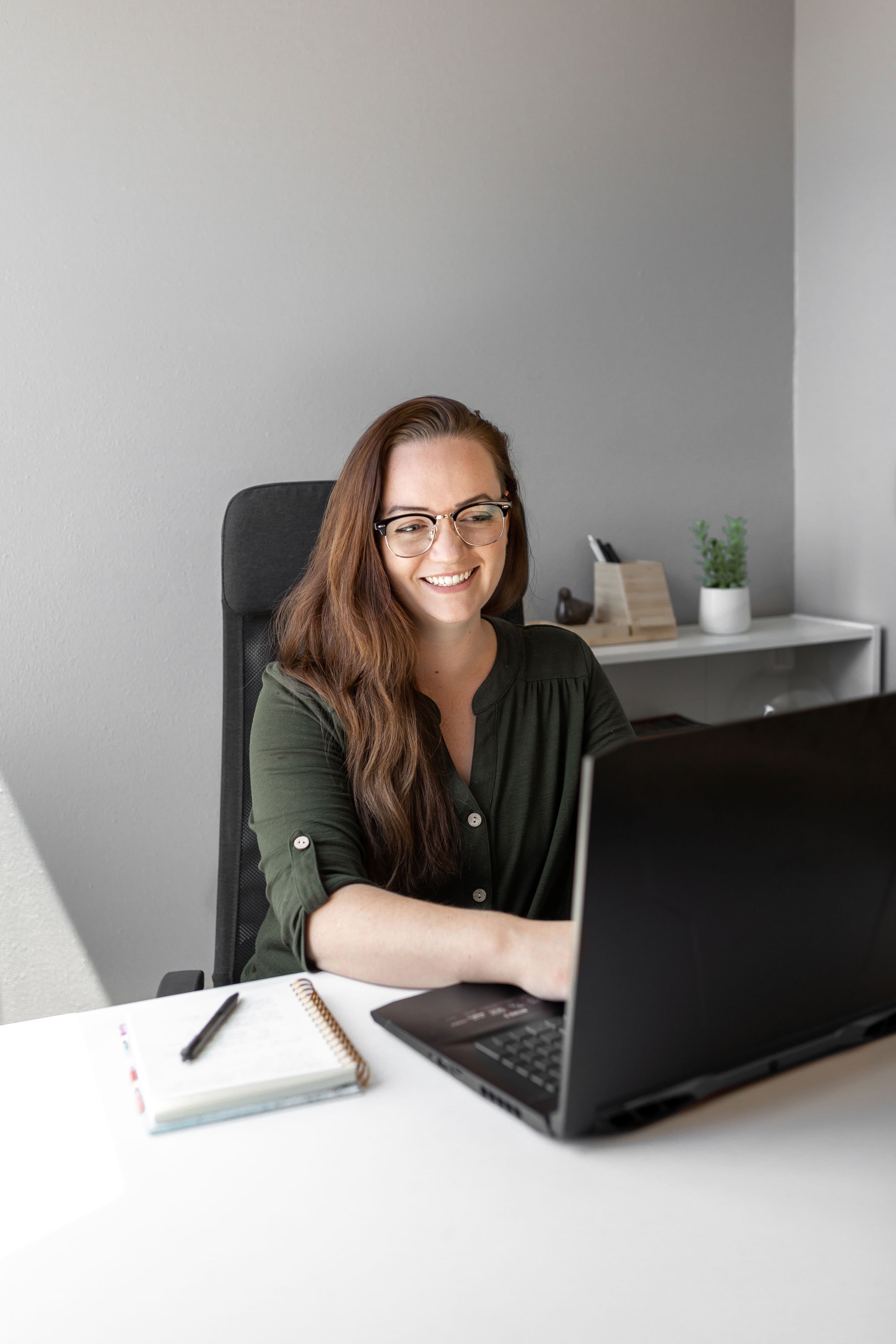 a woman working on a laptop and smiling