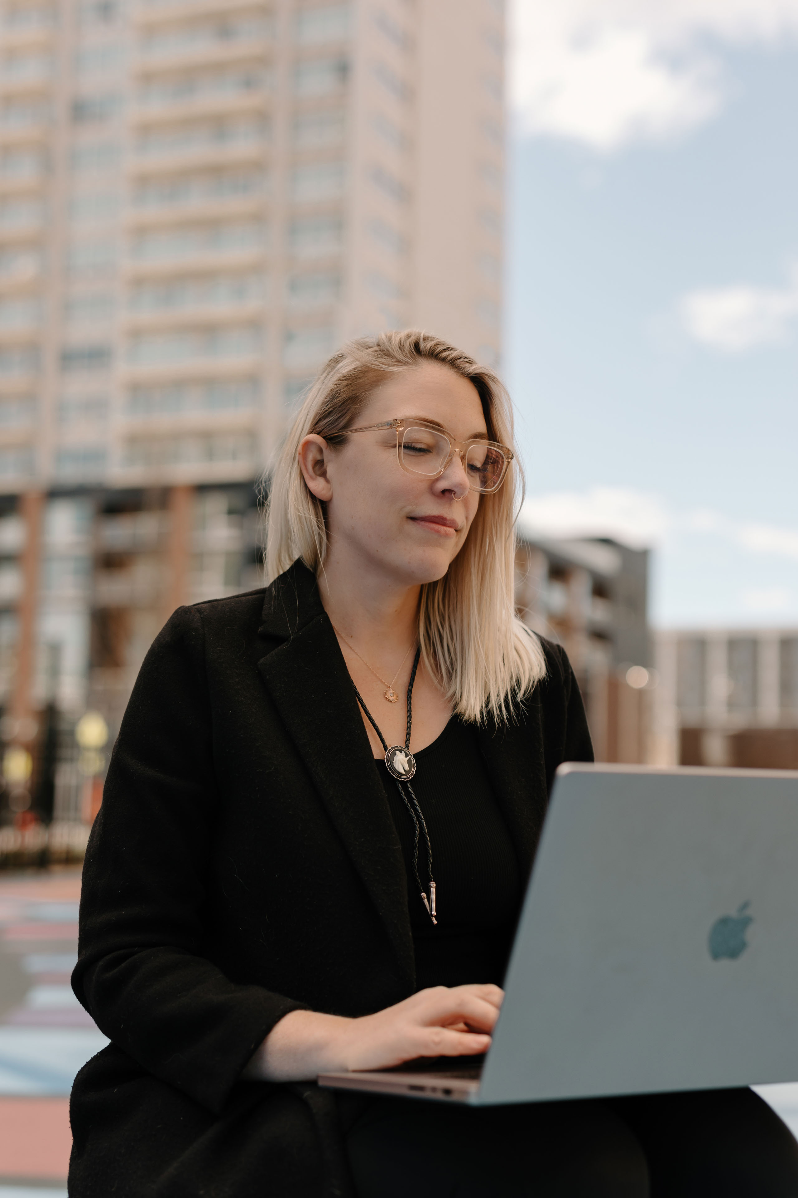 a woman working on a laptop in a colorful city