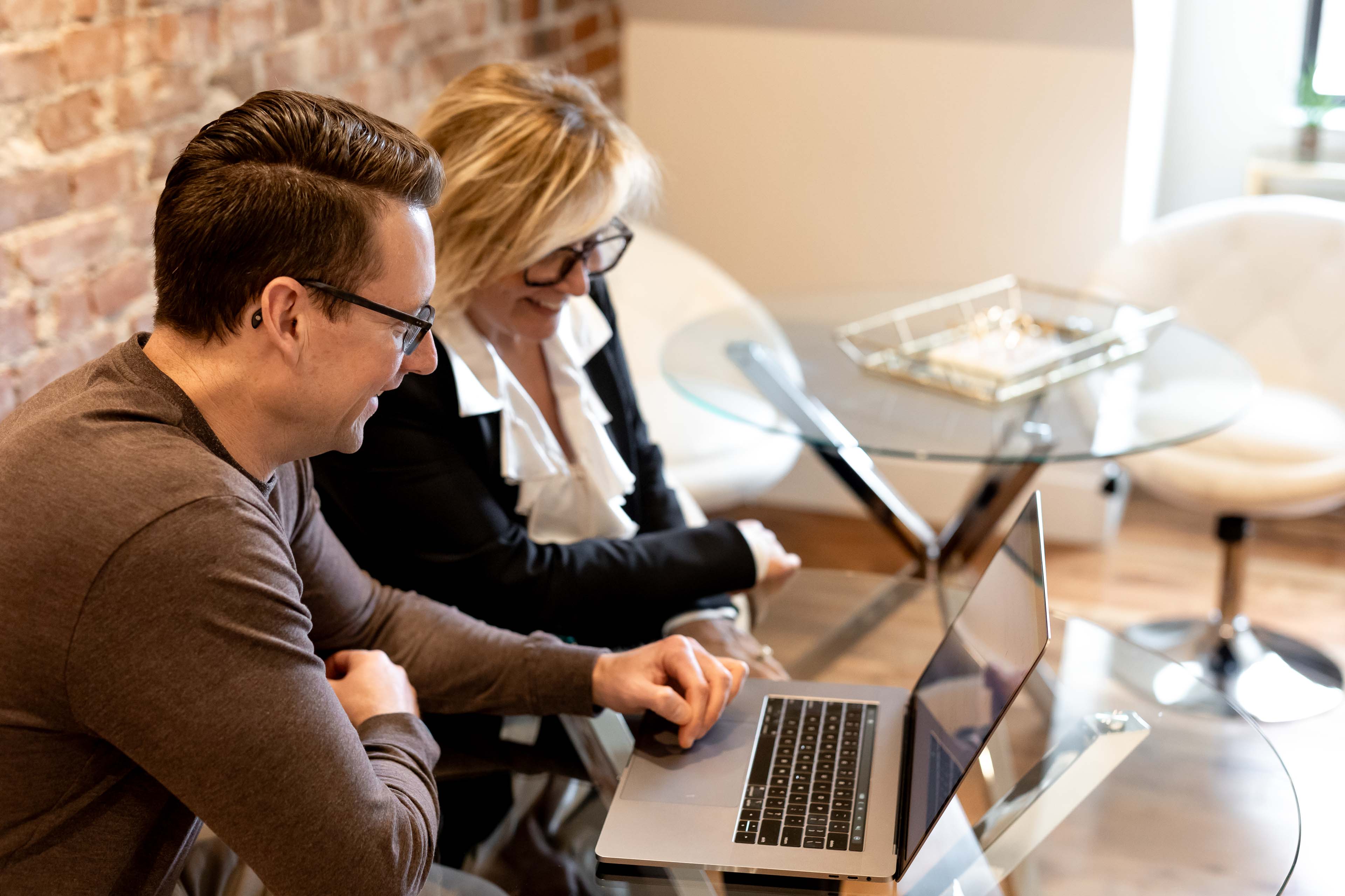 two people looking at a laptop