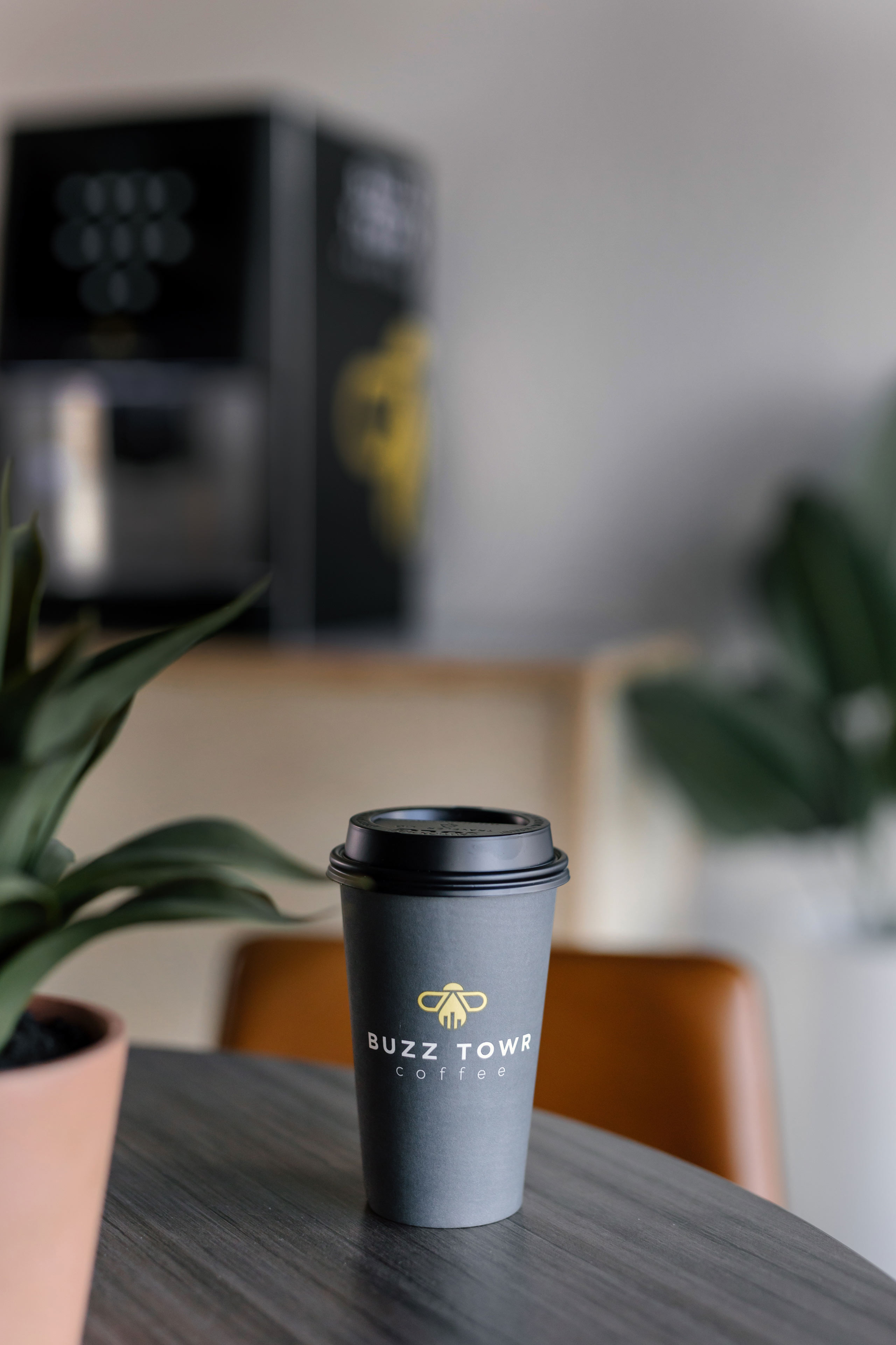 a to go cup of coffee with a Buzz Towr logo on it